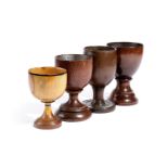 FOUR TREEN GOBLETS PROBABLY 19TH CENTURY including: one turned in oak, the underside of the foot