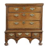 A QUEEN ANNE OAK CHEST ON STAND EARLY 18TH CENTURY the top with a moulded edge, above three long