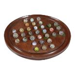 A VICTORIAN MAHOGANY SOLITAIRE BOARD LATE 19TH CENTURY together with thirty-three marbles (34) 31.