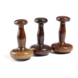 THREE TREEN LIGNUM VITAE SLICKEN STONES EARLY 19TH CENTURY of turned form (3) 15.4cm high (max)