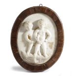 A FRENCH MARBLE RELIEF PLAQUE 18TH CENTURY depicting two naked boys, one wearing glasses, a bishop's