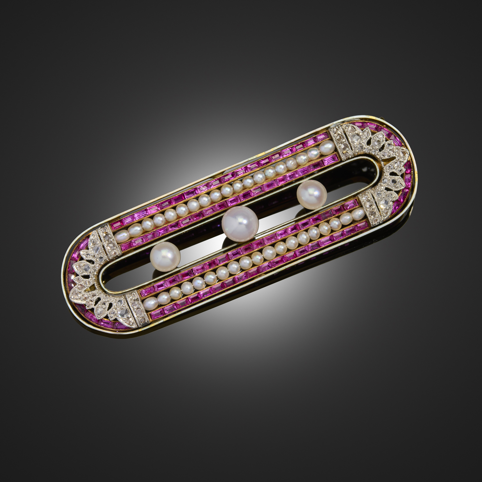 An early 20th century natural pearl, ruby and diamond brooch by Chaumet, the oval brooch centred