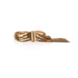 A gold 'brick' link bracelet, the six-row bracelet with tapered terminals and gold tassels (one