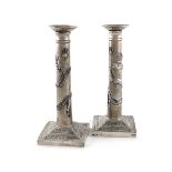 A pair of Chinese silver candlesticks, retailed by Wang Hing, tapering circular columns, mounted