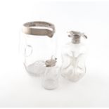 A small collection of silver-mounted glass items, comprising: a Victorian clear glass jug, London