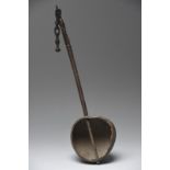 An Irian Jaya ladle Indonesia with a coconut shell bowl and a wood handle with a carved korvar