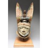 A Yoruba egungun helmet mask Nigeria the large ears united by a drum and a hare like animal, with