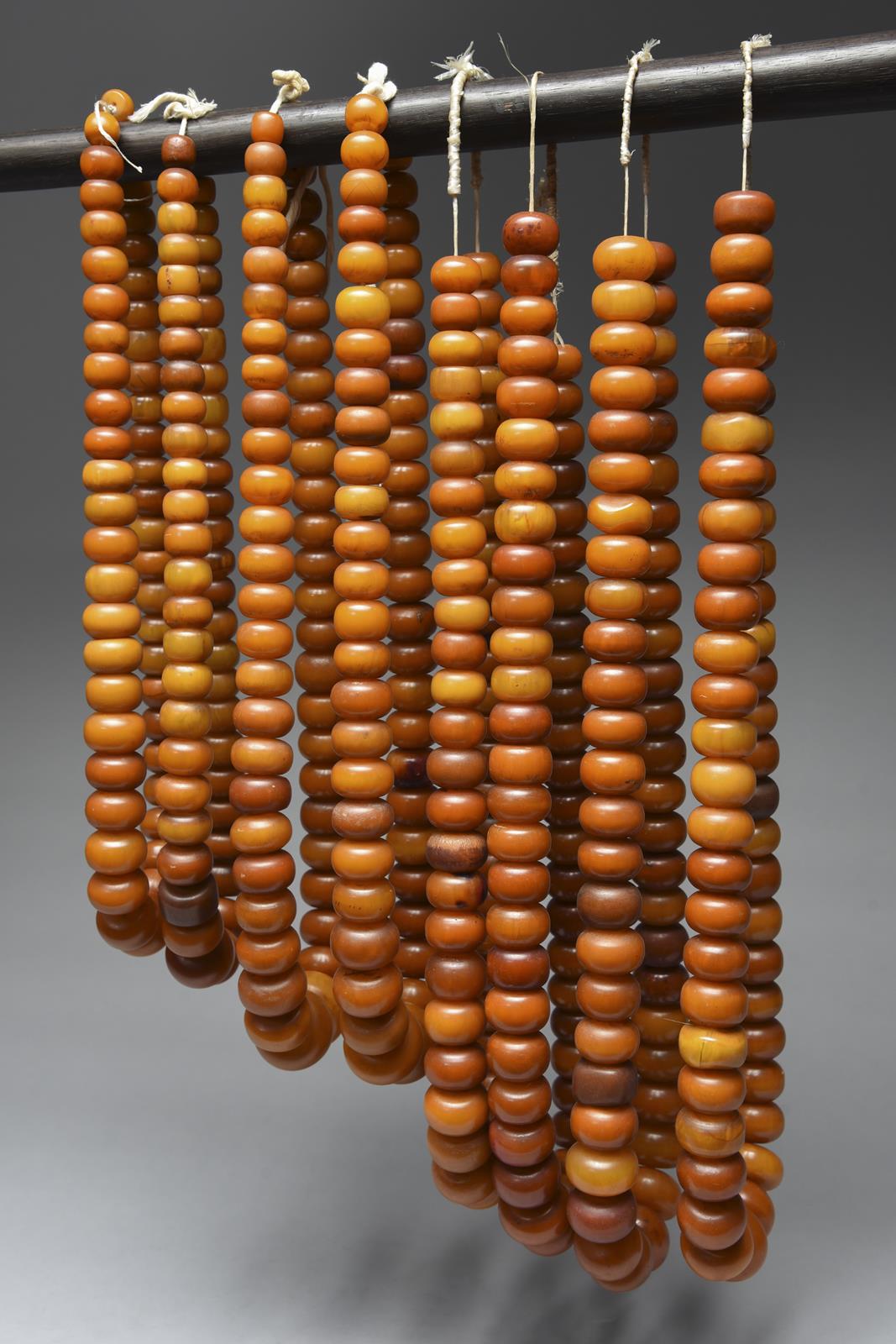 Eight West African copal bead necklaces the faux amber beads with fibre, the longest 53cm. (8)