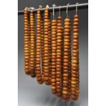 Eight West African copal bead necklaces the faux amber beads with fibre, the longest 53cm. (8)