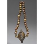 A Vere necklace Nigeria cast brass with thirty eight beads strung with a heavy disc pendant with a