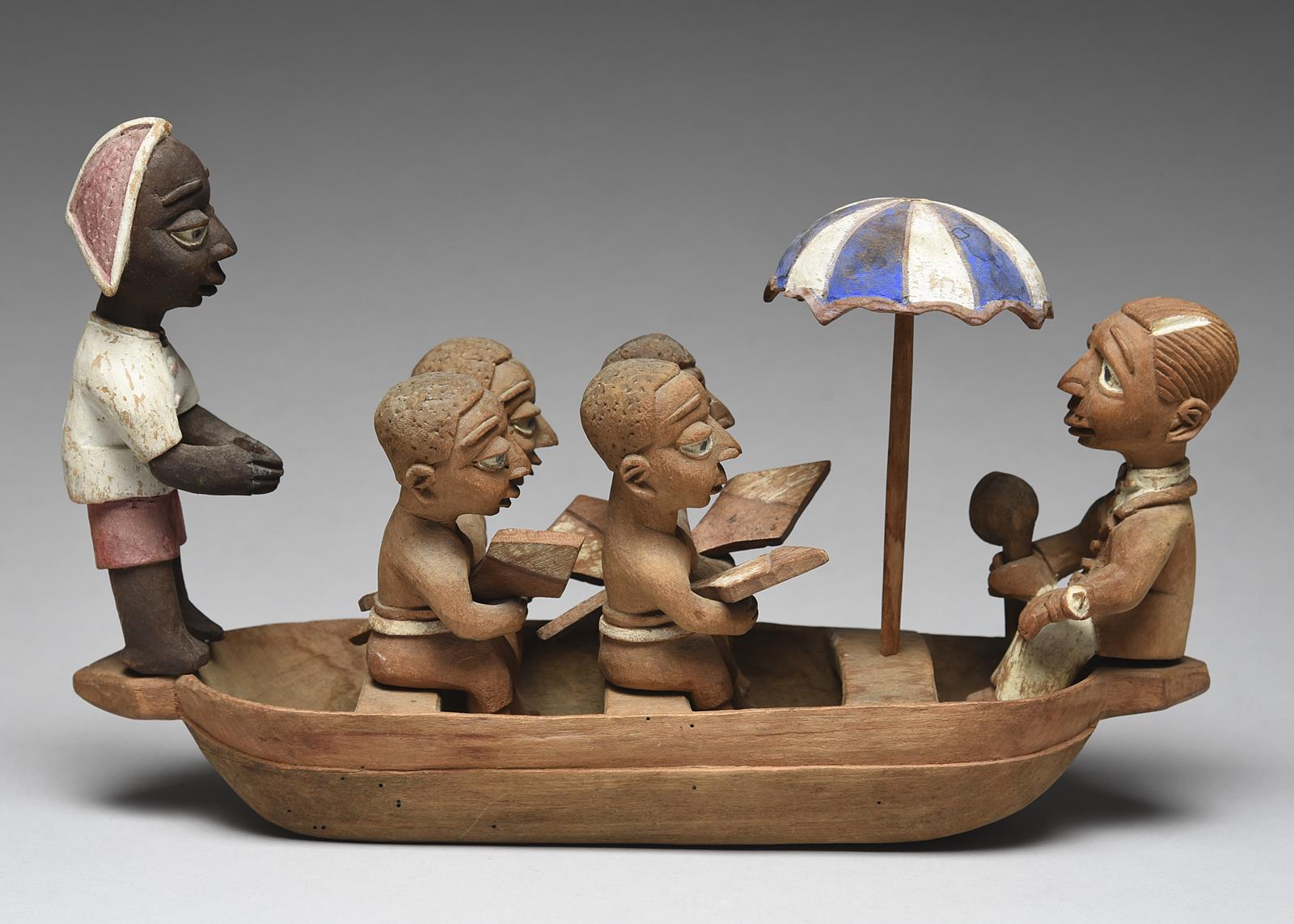 A Yoruba boat group by Thomas Ona Nigeria with a tiller man, four oarsmen with oars, an umbrella and