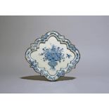 A Delft wall plaque, c.1720, the shaped form painted to the centre with insects in flight around a