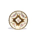 A Chelsea dessert plate, c.1760, painted ith a polychrome flower spray to the well within a shaped