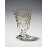 A rare English drinking glass or beaker, c.1750, the tall rounded funnel bowl deeply engraved with a