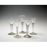 Five wine glasses, c.1750-60, with drawn trumpet bowls, three raised on plain stems with two