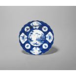 A Bow blue and white plate, c.1760, painted with a Fan Panelled landscape design, the well with a