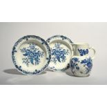 A pair of Worcester blue and white soup plates and a mask jug, c.1770-80, the plates printed with