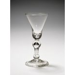 A baluster wine glass, c.1725, with a large bell bowl raised on an inverted baluster stem