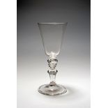 A large baluster wine glass or goblet, c.1720-30, the generous round funnel bowl raised on a