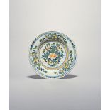 A London delftware plate, c.1770-80, painted in blue, green, red and yellow with a central peony