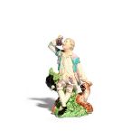 A Derby figure emblematic of Taste, c.1770, modelled as a young man seated on a rocky stump and