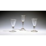 Three wine glasses, c.1740-50, one with a round funnel bowl on a plain stem with basal ball knop