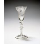 A large Jacobite wine glass, c.1755-60, the bell bowl engraved with a rose and bud spray above a