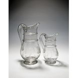 A graduated pair of glass jugs, late 18th century, roughly engraved with a leaf and barley design