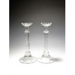 A large pair of cut glass candlesticks, 19th century, with spreading integral drip pans over knopped