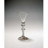 A rare wine glass, c.1750, with a drawn trumpet bowl raised on a short plain section above a