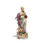 A Meissen figure of a Classical maiden or muse, mid 18th century, standing and holding a goblet,