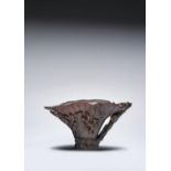 A CHINESE RHINOCEROS HORN 'LOTUS LEAF' LIBATION CUP 17TH CENTURY Modelled as a curly lotus leaf with