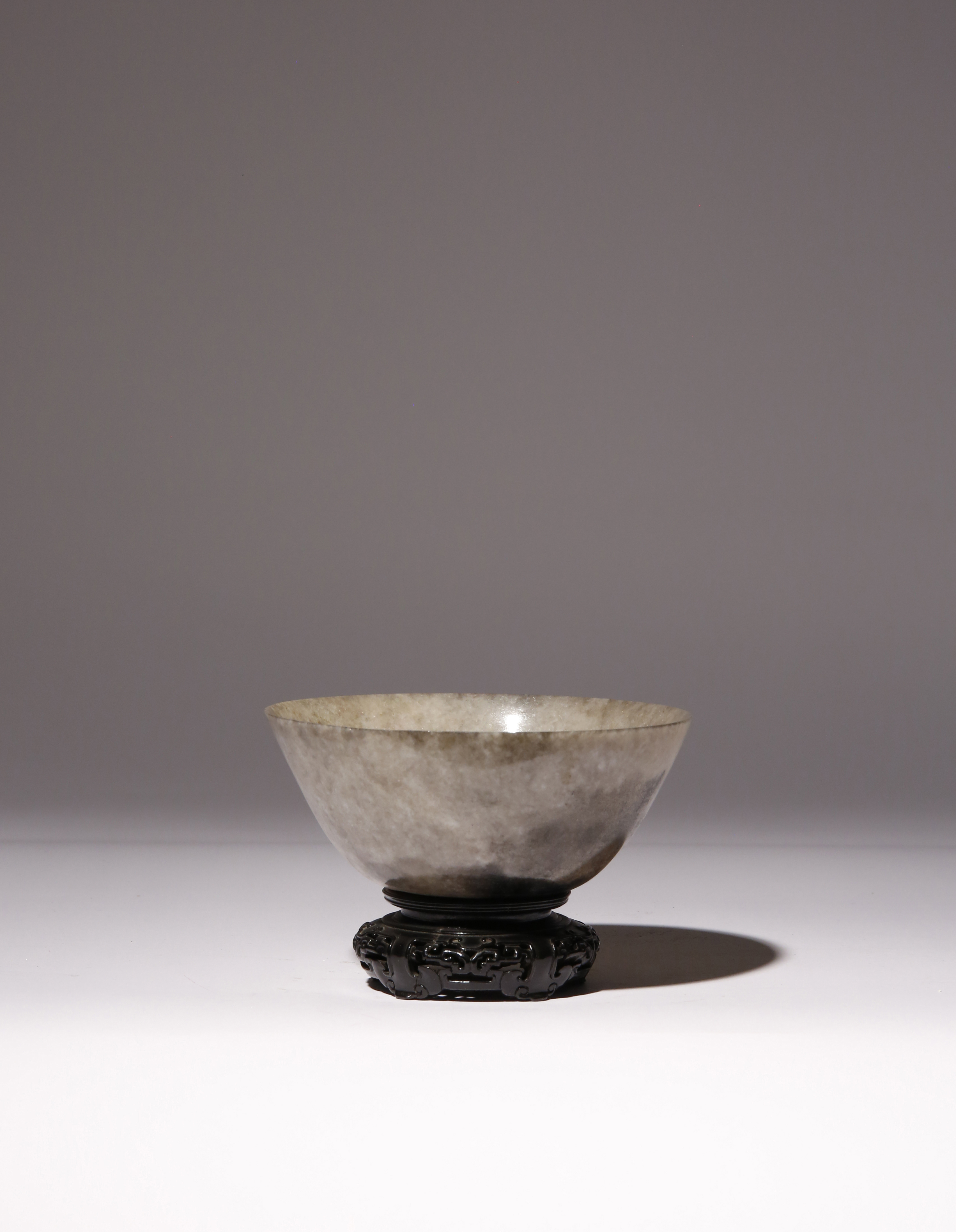 A CHINESE MOTTLED GREY AND BLACK JADE BOWL QING DYNASTY With curved sides gently thinning towards
