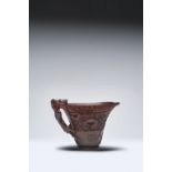 A CHINESE RHINOCEROS HORN ARCHAISTIC LIBATION CUP 17TH/18TH CENTURY The tapering body carved in