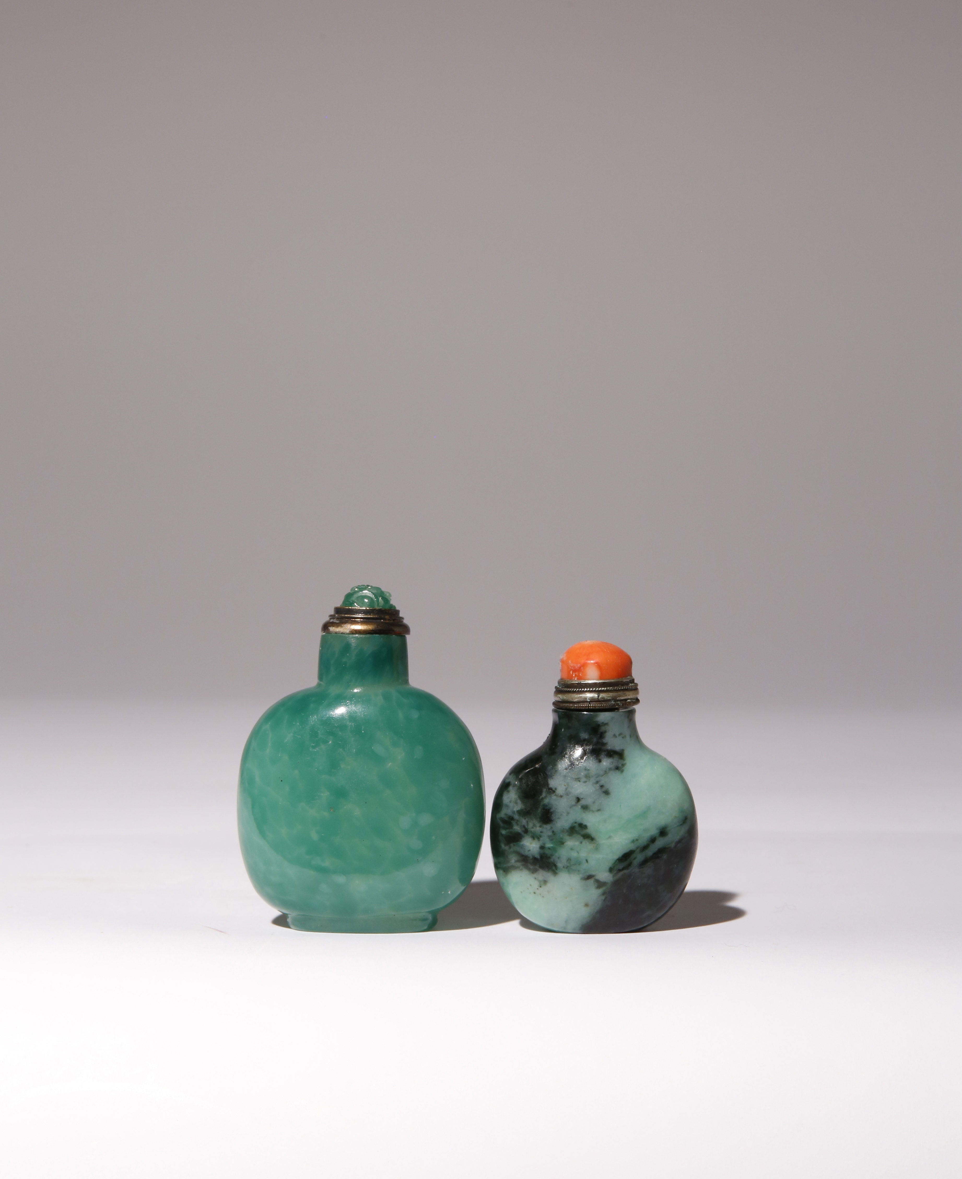 A CHINESE JADEITE SNUFF BOTTLE AND A GLASS SNUFF BOTTLE QING DYNASTY Each of flattened rounded