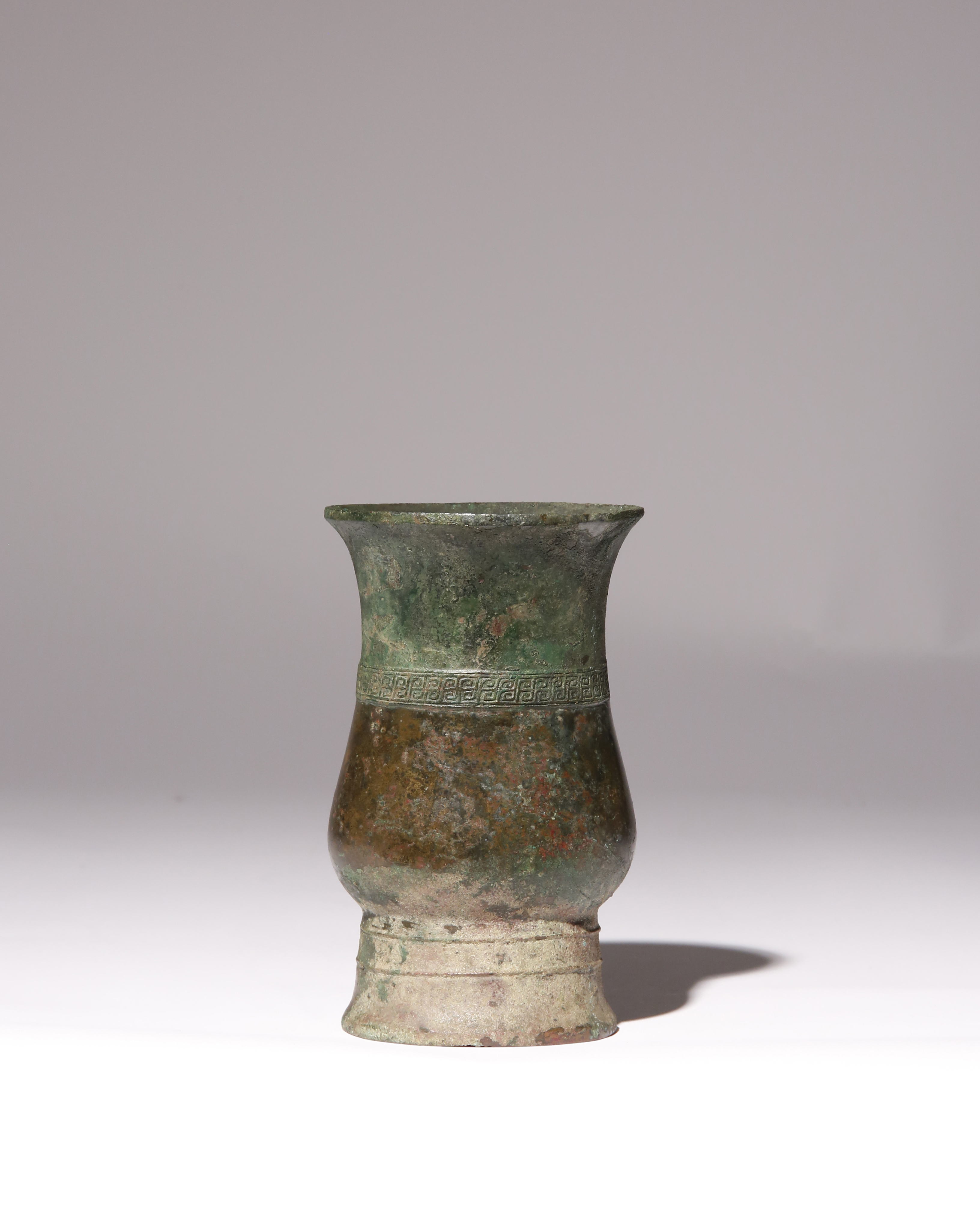 A CHINESE ARCHAIC BRONZE WINE VESSEL, ZHI SHANG DYNASTY The pear-shaped oval body cast with a band