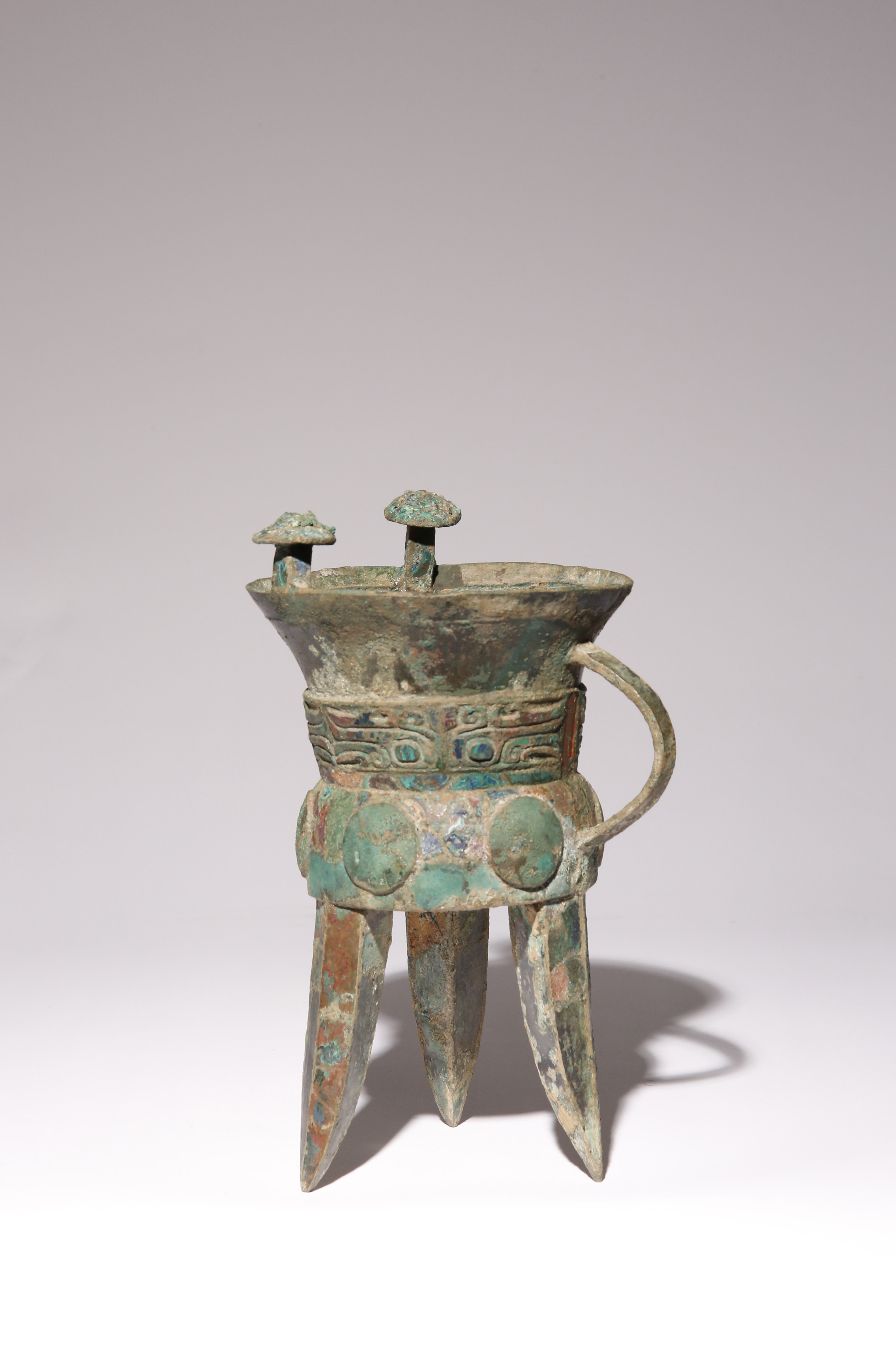 A CHINESE ARCHAISTIC BRONZE TRIPOD WINE VESSEL, JIA SHANG DYNASTY OR LATER Raised on three blade-