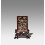 A CHINESE CARVED HARDWOOD SMALL TABLE SCREEN QING DYNASTY OR LATER The rectangular panel carved with