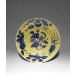 A CHINESE YELLOW-GROUND BLUE AND WHITE 'FRUITS AND FLOWERS' DISH QING DYNASTY The shallow flaring