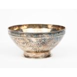 An A E Jones silver footed bowl, the shallow drum foot cast with strap decoration, the flaring