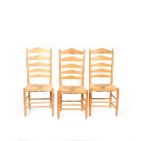 Three natural ash Gimson ladderback (no.1A) chairs by Neville Neal, with rush seats, stamped Neville