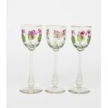 A set of three Art Nouveau enamelled glass wine glasses the design attributed to Helen or Hannah