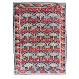 A woven wool carpet, rectangular, floral repeat inside border, red, blue and cream, 307 x 202cm.