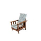 An oak reclining armchair in the manner of Liberty & Co, with slat back and pull out seat, on