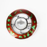 A silver and enamel brooch, pierced circular form, the rim with a band of red and green enamel,