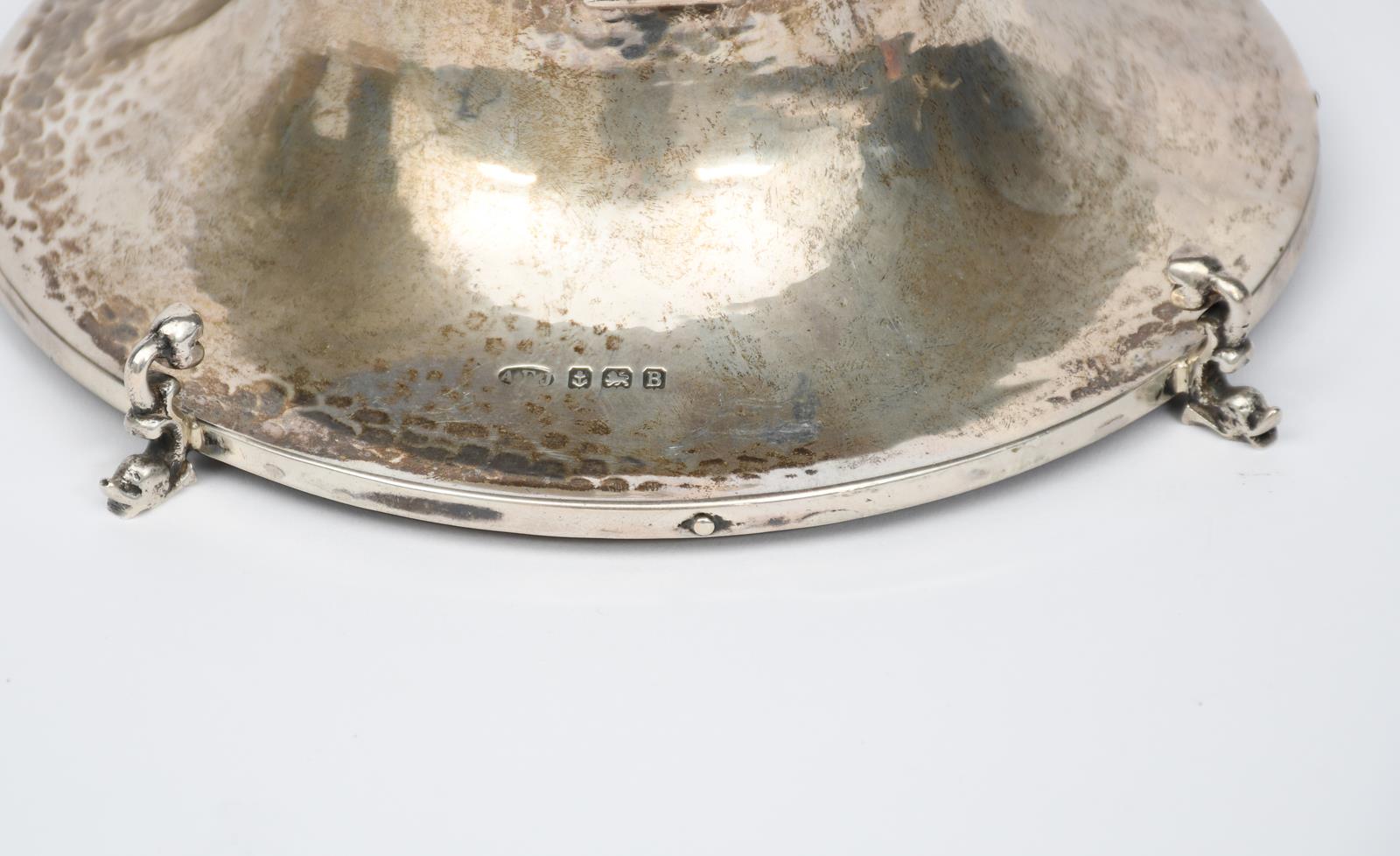 An A E Jones silver inkwell, circular form on dolphin feet, tapering hammered body, the hinged cover - Image 2 of 2