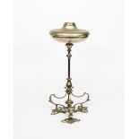 A tall silvered metal oil lamp base, tripod foliate foot, knopped stem supporting oil reservoir,