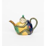 A Minton majolica monkey teapot and cover, modelled as a seated monkey holding a large gourd,