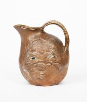 An unusual and rare Martin Brothers stoneware face jug by Robert Wallace Martin, dated 1897,