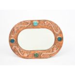 A John Pearson repousse copper wall mirror, rounded rectangular form set with four Ruskin ceramic